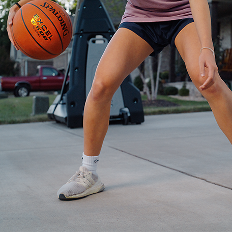 Female model dribbling Excel TF-500 in driveway.  